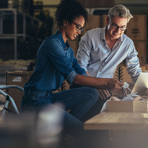 Two people preparing a package shipment.